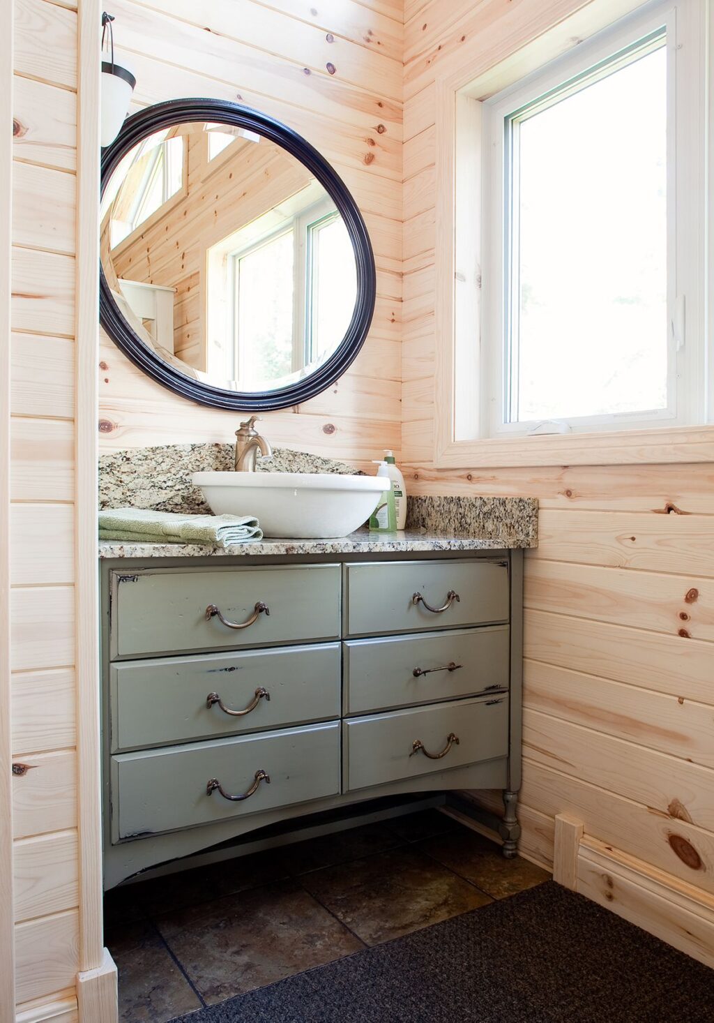 cottage bathroom in a rustic style. distressed vanity and vessel sink with tongue and groove pine walls