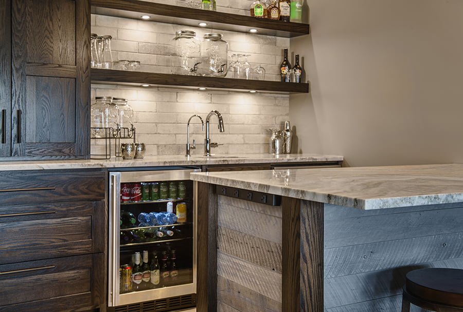 interior design and home renovation home bar area with dark wood cabinets, stone countertops and integrated bar fridge