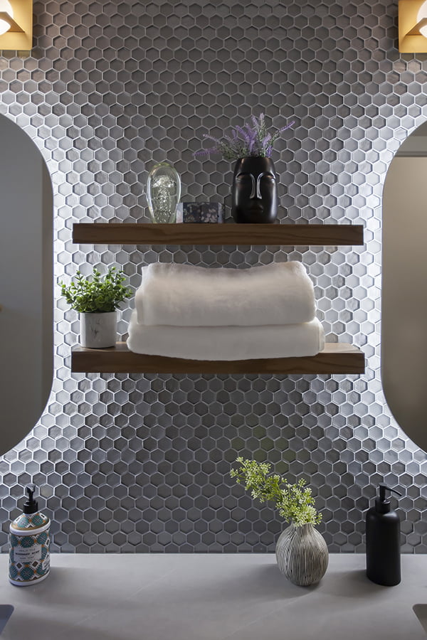 custom floating shelves on glass tiled bathroom vanity backsplash