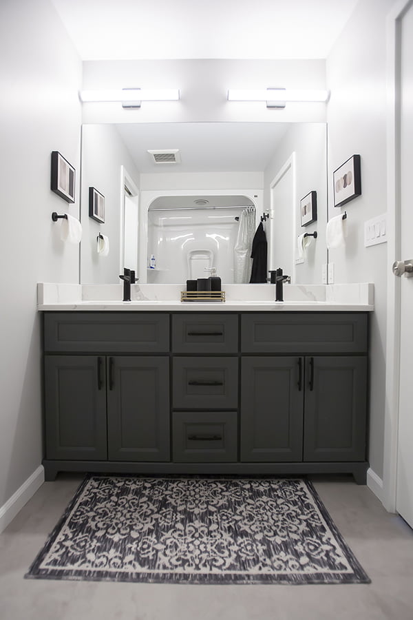 bathroom vanity with custom cabinets and wall mounted lighting