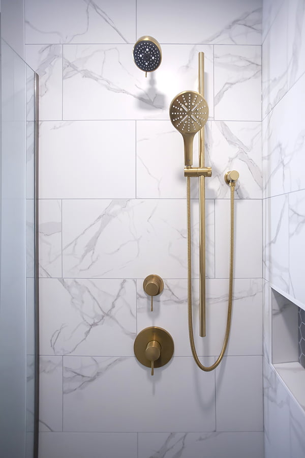 bathroom remodel with tile walls and brushed gold fixtures