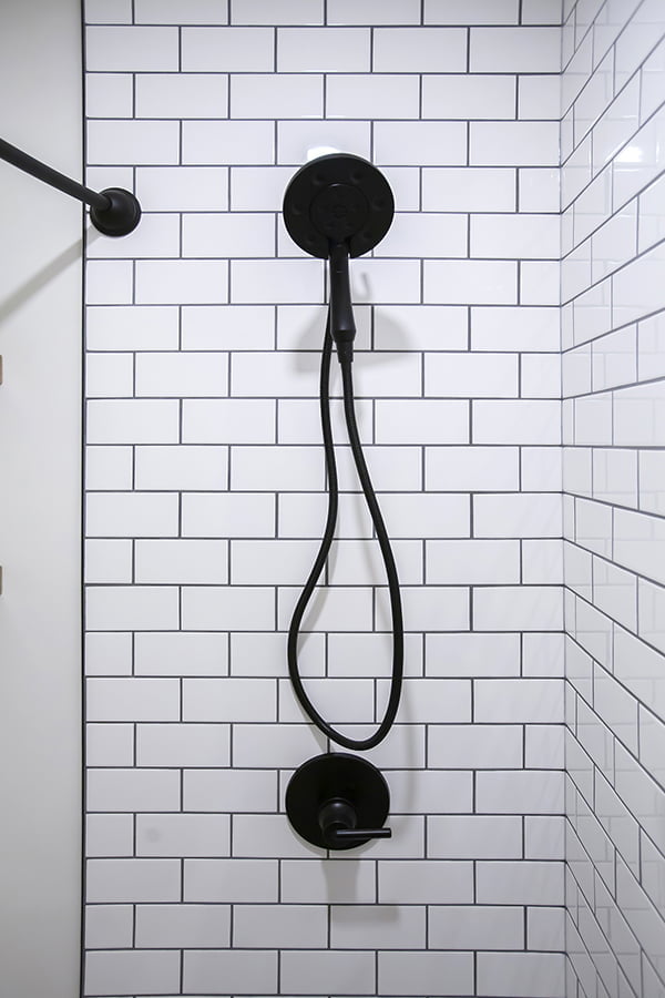 subway-tiled shower with black hardware