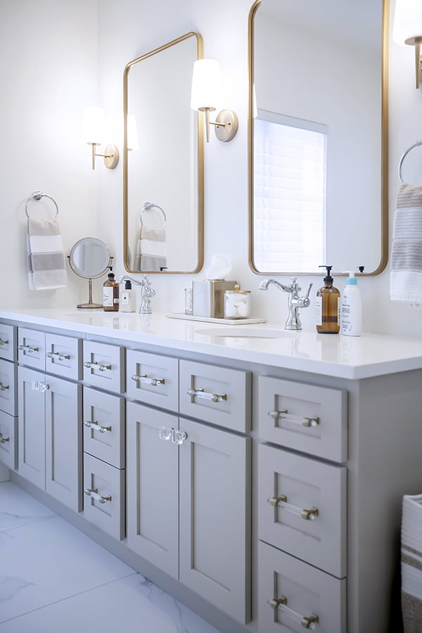 ensuite renovation with double sink, stone countertops and wall sconces