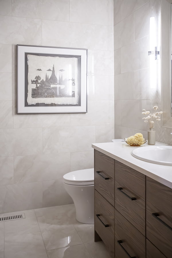 custom bathroom design with wood vanity, drop-in sink and tiled walls